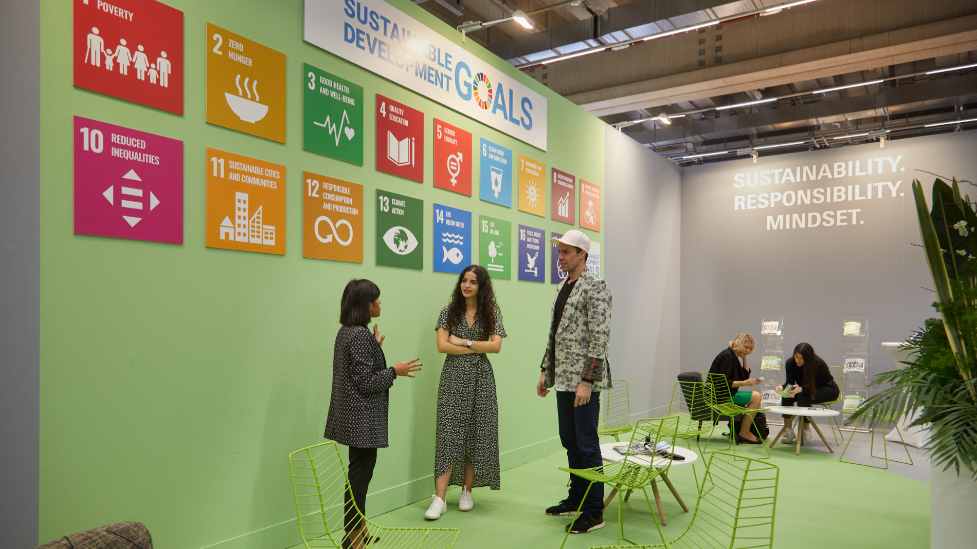 3 people in front of an SDG wall